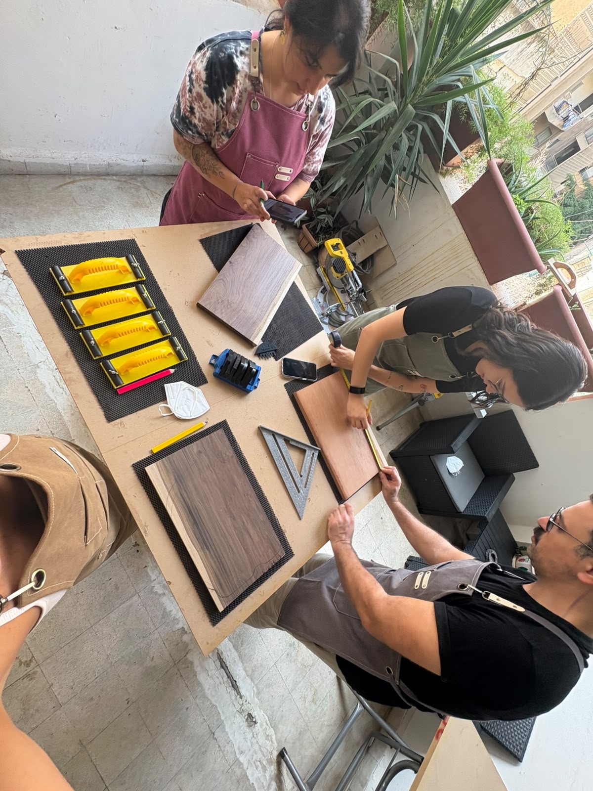 Guests measuring and marking their boards at the workbench