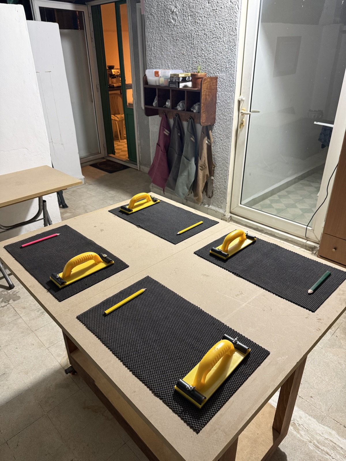 The workbench set for four, with sanding blocks and pencils